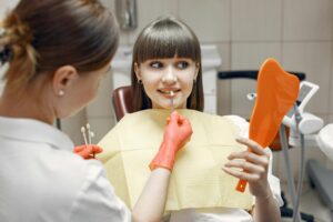 Are dental implants permanent. Young woman getting shade of implant.